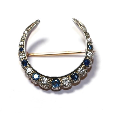 Lot 109 - A sapphire and diamond crescent brooch, set throughout with graduated round cut sapphires and...