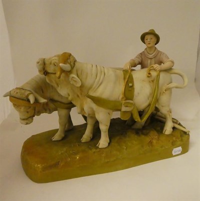 Lot 190 - A large Royal Dux figure group, formed as a farm hand and pair of oxen, raised on a...