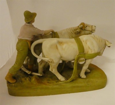 Lot 190 - A large Royal Dux figure group, formed as a farm hand and pair of oxen, raised on a...