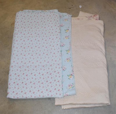 Lot 1106 - A quilt with pink printed flower heads to one side, cream to the reverse and a pale blue double...