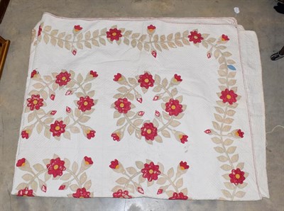 Lot 1171 - A late 19th century white cotton quilt, decorated with circular floral garlands of red flower heads