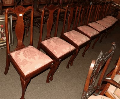 Lot 1306 - A set of eight carved mahogany dining chairs raised on plain cabriole supports (8)