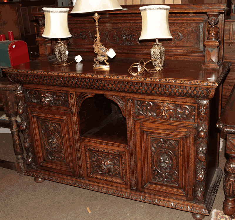 Lot 1321 - A Gothic revival carved oak sideboard, ornamented with masks and ecampus scrolls, 154cm by 57cm...