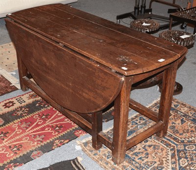 Lot 1323 - An 18th century and later oak drop leaf table, 137cm diameter