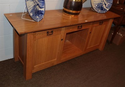 Lot 1350 - A Treske Furniture solid oak sideboard, the rectangular top above a central frieze door over a...