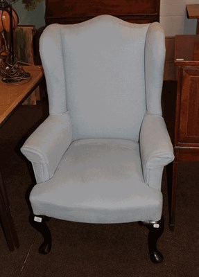 Lot 1354 - A Georgian style upholstered wingback armchair raised on cabriole legs