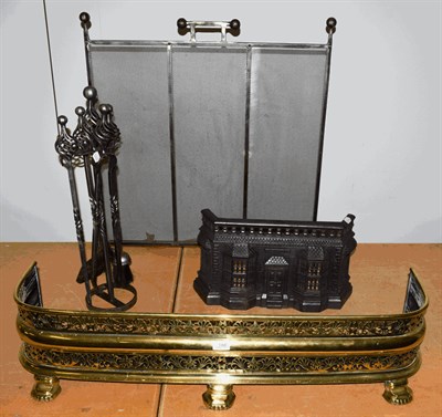 Lot 1360 - A Victorian pierced brass fire fender, 99cm wide, a spark guard, a fireside companion set and a...