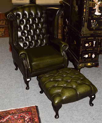 Lot 1365 - A Thomas Lloyd green leather Chesterfield wingback armchair with deep buttoned footstool (2)