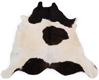 Lot 251 - Skins/Hides: A Cow Hide Rug (Bos taurus), modern, a dark brown and white patterned cow hide...