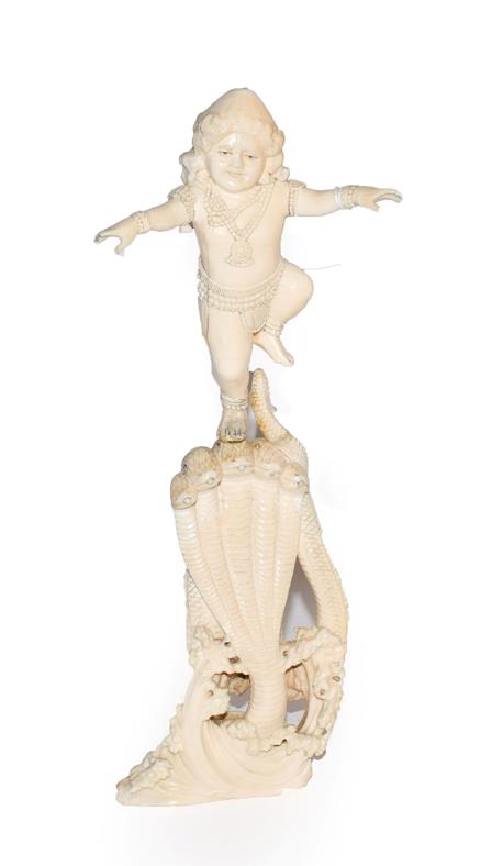 Lot 60 - A 19th century Indian carved ivory figure of a Deity stood on a pedestal of five snakes, 30cm high
