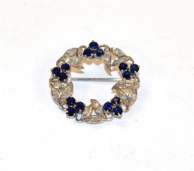 Lot 137A - A sapphire and diamond brooch, realistically modelled as a wreath, clusters of three round cut...