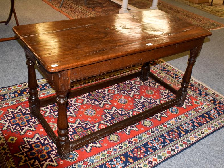 Lot 1094 - A joined oak refectory table, with plain frieze, on turned legs with block feet joined by a...