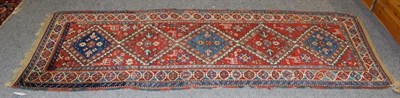 Lot 1101 - A Gendje runner, 19th century, the blood red field with a column of stepped medallions...