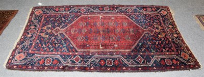 Lot 1102 - A Hamadan rug, the indigo field with a madder lozenge enclosed by borders of angular vines,...
