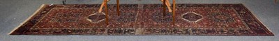 Lot 1103 - A Heriz runner, the terracotta field with a column of medallions enclosed by indigo borders,...