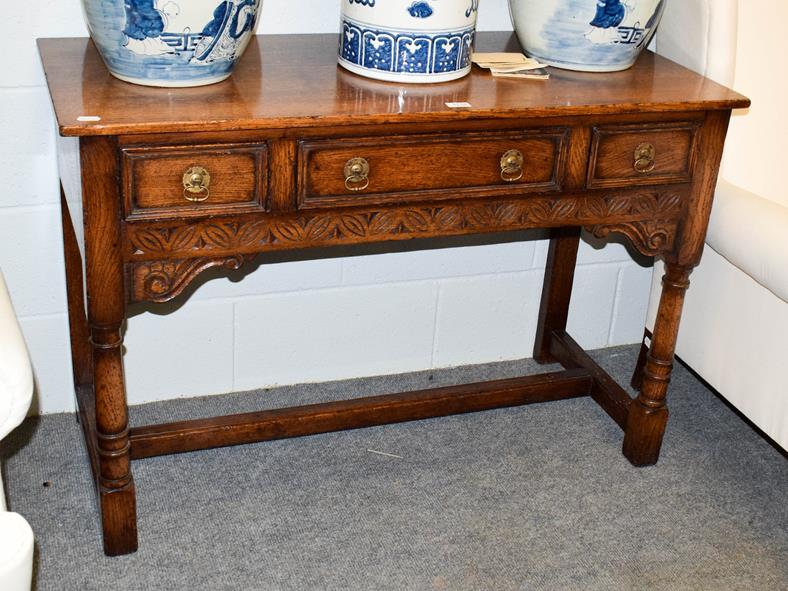 Lot 1118 - A Titchmarsh & Goodwin carved oak three drawer side table, with turned supports and...