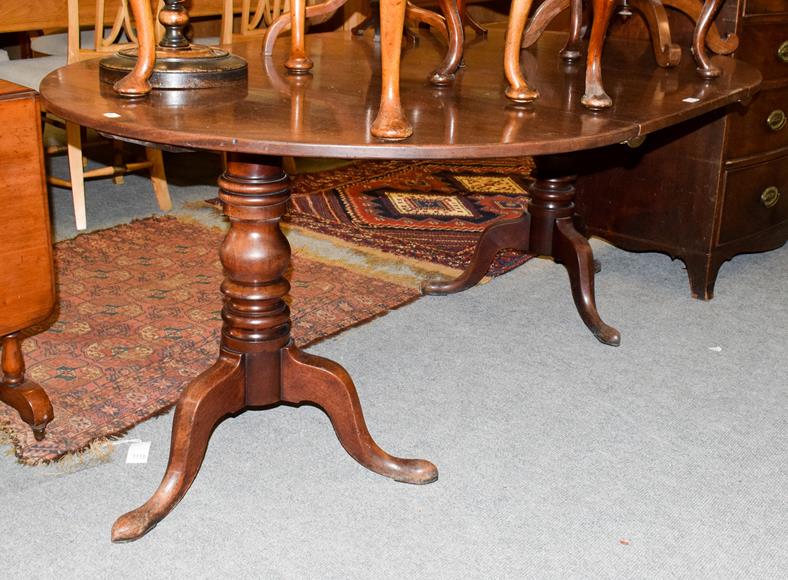 Lot 1145 - A Georgian mahogany D-end twin-pillar dining table with additional leaf, 117cm by 173cm (open)...