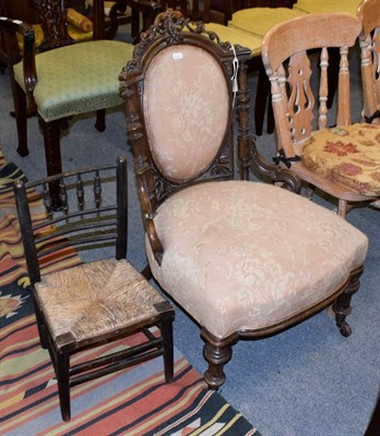 Lot 1179 - A Victorian carved walnut nursing chair, together with a child's rush seat chair (2)