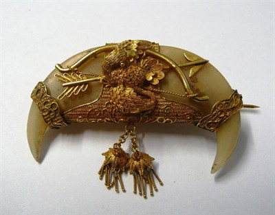 Lot 446 - A Double Tiger's Claw Brooch, with filigree overlay depicting a bird over a bow and arrow and...