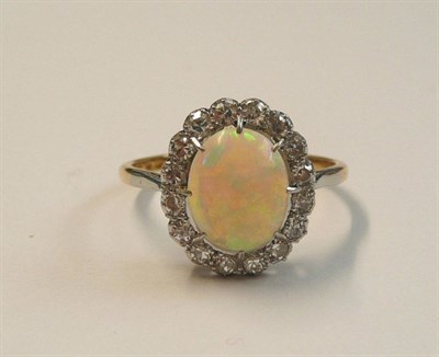 Lot 448 - An Opal and Diamond Cluster Ring, the oval cabochon opal within a border of eight-cut diamonds,...