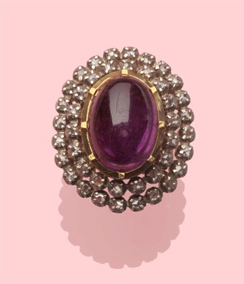 Lot 461 - An Amethyst and Diamond Cluster Ring, a cabochon amethyst within a double border of rose cut...