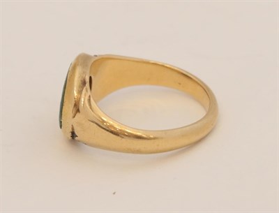 Lot 154 - ~ A Green Glass Signet Ring, the oval intaglio seal, inset into a yellow tapered shank, finger size
