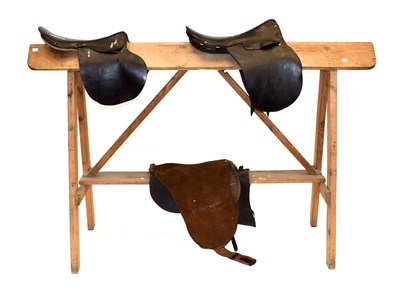 Lot 208 - ~ A Pine Saddle Horse, on trestle supports; also, two vintage leather general purpose saddles,...