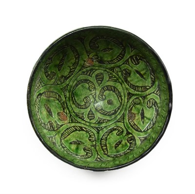 Lot 282 - A Garrus Green Glazed Earthenware Bowl, 12th/13th century, carved and incised through the black...