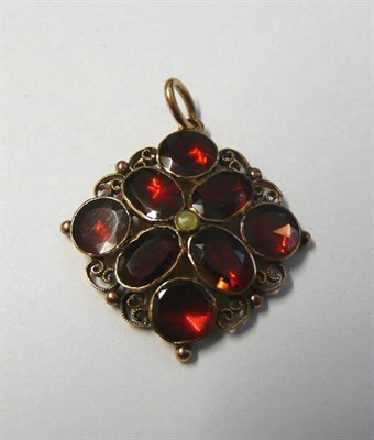 Lot 500 - A Garnet Cluster Pendant, the oval and round cut foil backed stones in closed back settings,...