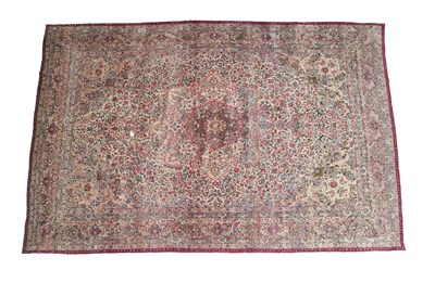 Lot 341 - Large Kirman Carpet South East Iran, circa 1920 The ivory field richly decorated with flowering...