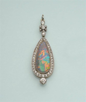 Lot 509 - An Art Deco Black Opal and Diamond Cluster Pendant, the cabochon pear cut black opal within a...