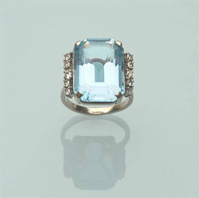 Lot 511 - An Aquamarine and Diamond Ring, the step cut aquamarine with truncated corners flanked by a row...