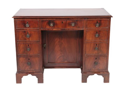 Lot 490 - <> A George III Mahogany Kneehole Desk, early 19th century, the moulded top above one long and...