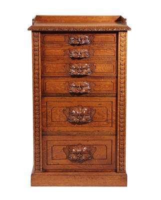 Lot 528 - A Late Victorian Carved Oak Wellington Chest, late 19th century, the three-quarter gallery...