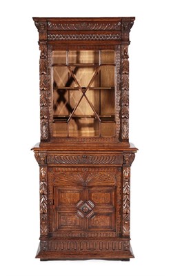 Lot 540 - A Victorian Carved Oak Bookcase, circa 1870, the upper section with bevelled glass glazed door...