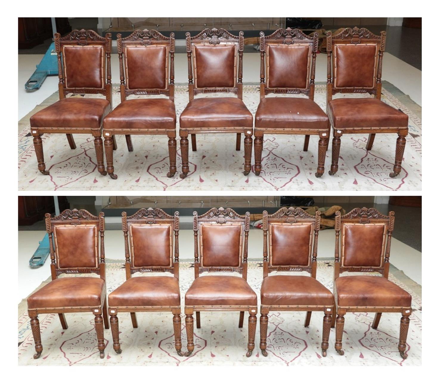 Lot 627 - A Set of Ten Victorian Carved Oak Dining Chairs, late 19th century, recovered in nailed brown...
