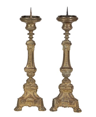 Lot 696 - ^ A Pair of Gilt Metal Altar Candlesticks, late 19th/early 20th century, each with shaped...
