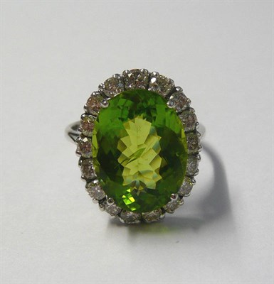 Lot 538 - An 18 Carat White Gold Peridot and Diamond Ring, an oval cut peridot within a border of round...