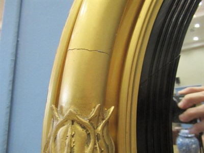 Lot 712 - A Regency Gilt and Ebonised Circular Convex Mirror, early 19th century, with a reeded slip...