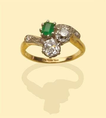 Lot 546 - An Emerald and Diamond Cluster Ring, a step cut emerald and two old cut diamonds in a white...