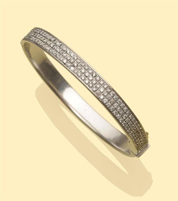 Lot 550 - A Diamond Bangle, the hinged polished white metal bangle inset with three rows of round...