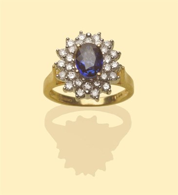 Lot 552 - An 18 Carat Gold Sapphire and Diamond Cluster Ring, an oval cut sapphire within two rows of...