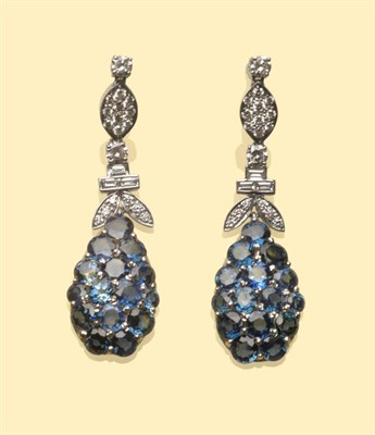 Lot 555 - A Pair of 18 Carat White Gold Sapphire and Diamond Drop Earrings, a shaped drop set with round...