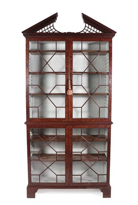 Lot 59 - A George III Mahogany Bookcase, 18th century, the broken arch pediment with trellis panels...