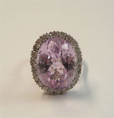 Lot 559 - An 18 Carat White Gold Kunzite and Diamond Cluster Ring, the oval cut kunzite within a border...