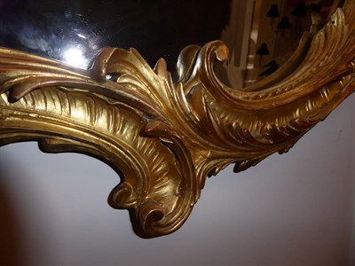 Lot 68 - A Victorian Carved Giltwood Mirror, mid 19th century, the cartouche shaped bevelled plate within an