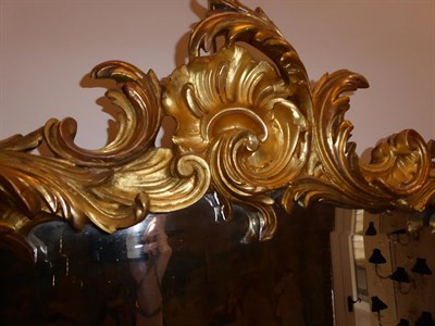 Lot 68 - A Victorian Carved Giltwood Mirror, mid 19th century, the cartouche shaped bevelled plate within an