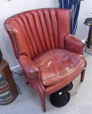 Lot 146 - A 20th Century Barrel Shaped Library Armchair, covered in close-nailed red leather, with...