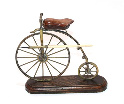Lot 151 - A Late Victorian Brass and Oak Novelty Deskstand, in the form of a ''penny farthing'', the...