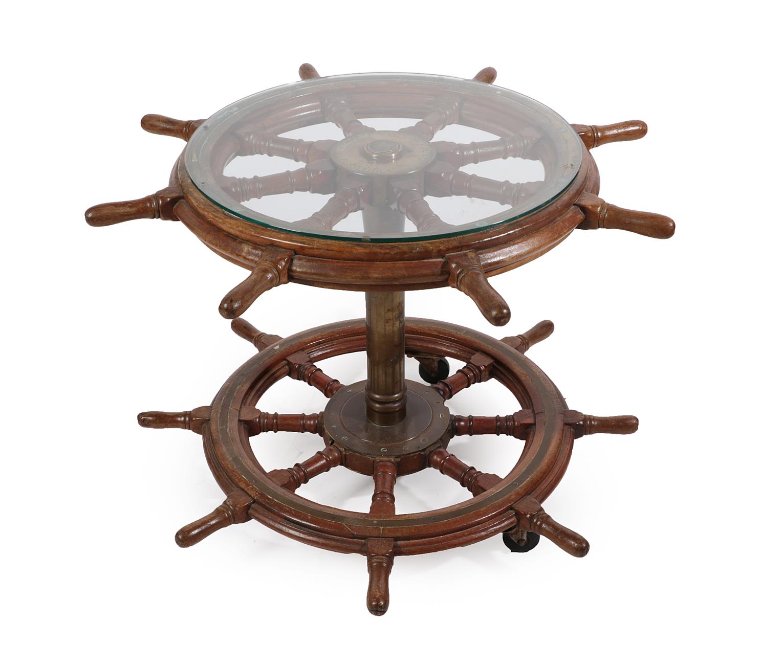 Lot 157 - A Ship's Helm Table, with circular glass top, constructed from two helms on a brass column support